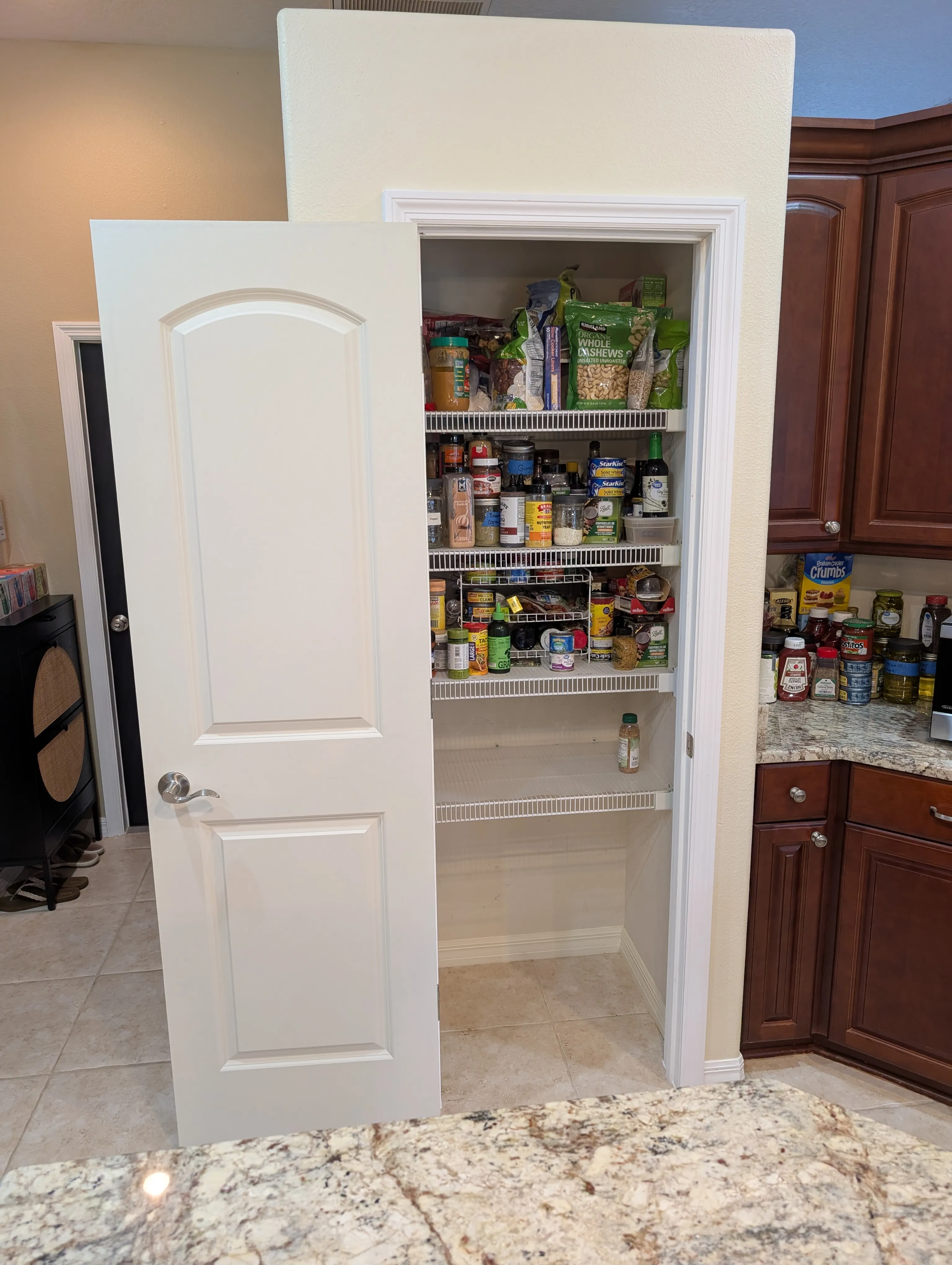 After: Cramped white bifold pantry doors replaced with a single pre-hung door and fresh casing, opening the pantry up for more light and easier access